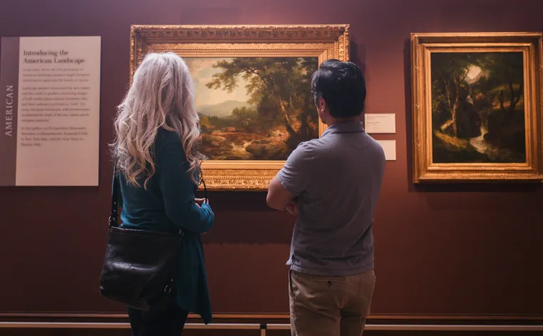 Two visitors looking at art