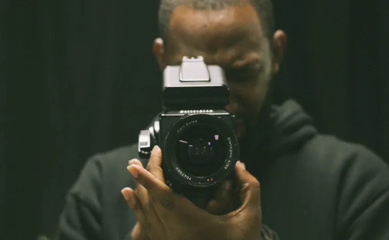 Elonte Davis facing the camera, holding a camera