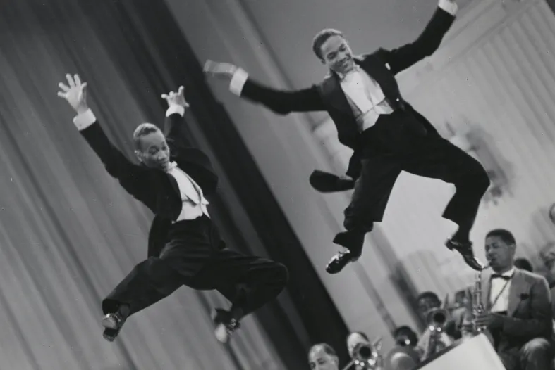 The Nicholas Brothers in a scene from Stormy Weather (1943), from left, Fayard Nicholas and Harold Nicholas. Photographic print, gelatin silver. Courtesy Margaret Herrick Library, ©Twentieth Century