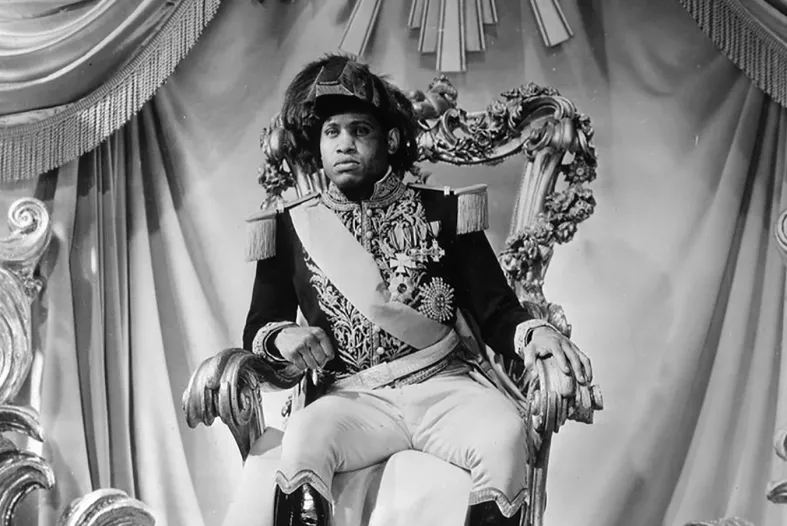 A man in a French captain's uniform sits on a throne.