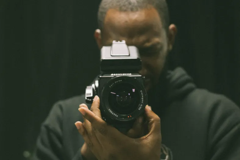 Elonte Davis facing the camera, holding a camera
