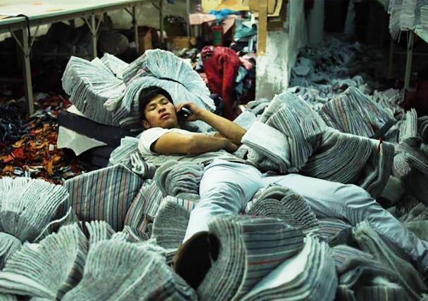 A person laying amongst packs of towels