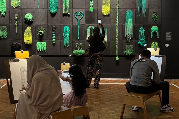 Museum visitors drawing in the exhibition Tiff Massey: 7 Mile + Livernois at the Detroit Institute of Arts