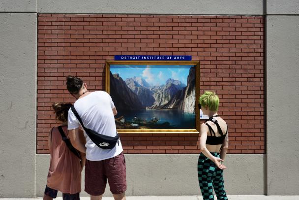 Three friends looking at an artwork on the side of a building during an Inside|Out Installation