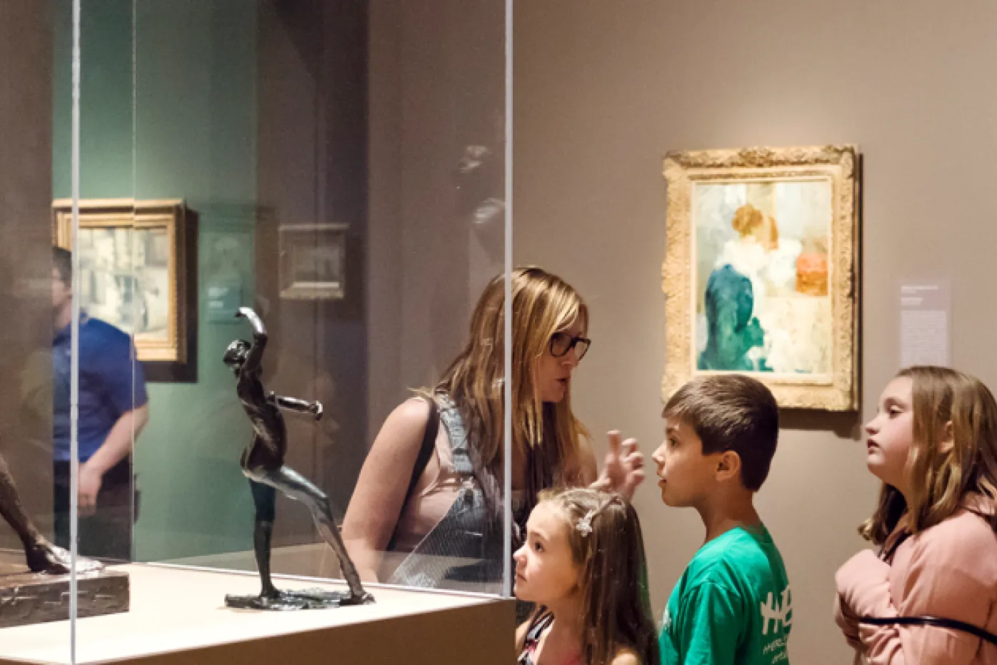 A family viewing a Degas sculpture in Humble and Human: Impressionist Era Treasures