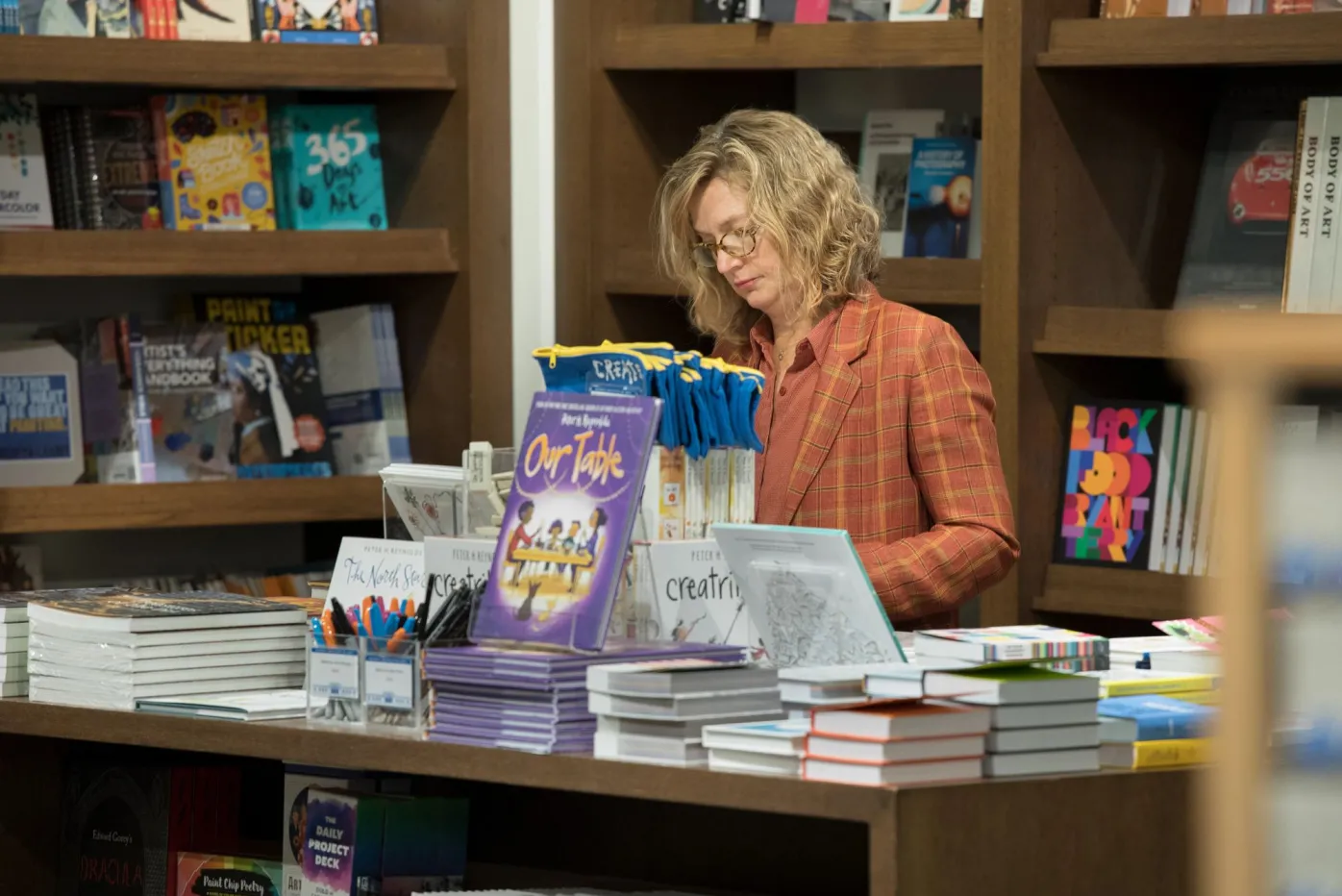 A patron browsing books for sale in the DIA Shop