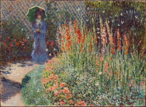 Lady in blue with an umbrella in a flower garden