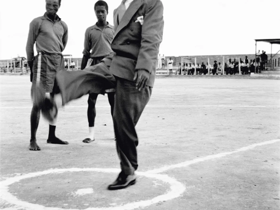 James Barnor (Ghana, b. 1929). Kwame Nkrumah in his prison graduate cap, kicking a soccer ball before the start of an international match at Owusu Memorial Park, Fadama neighborhood, Accra, 1952 (printed 2010–20). Gelatin silver print. Autograph, London.