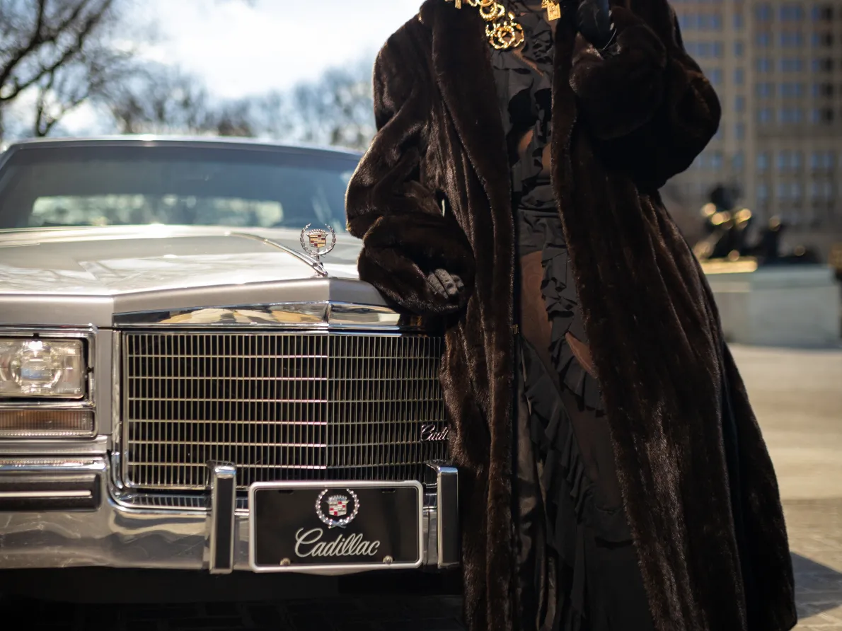 Tiff Massey exhibition. Tiff is standing next to a car in front of the Detroit Institute of Arts.