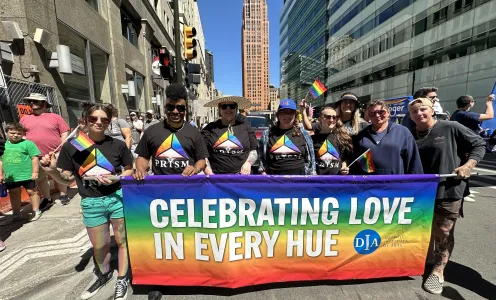 DIA staff and Prism members pose with their Pride parade banner