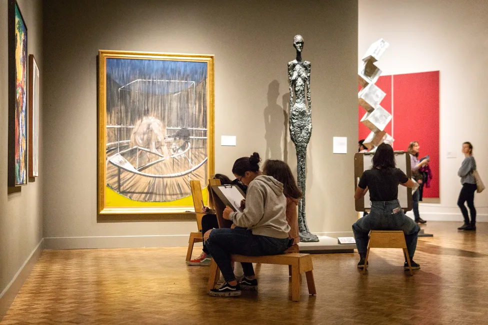 Visitors drawing on stools in the modern art galleries at the DIA
