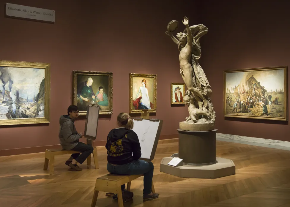 Two visitors drawing in the modern galleries