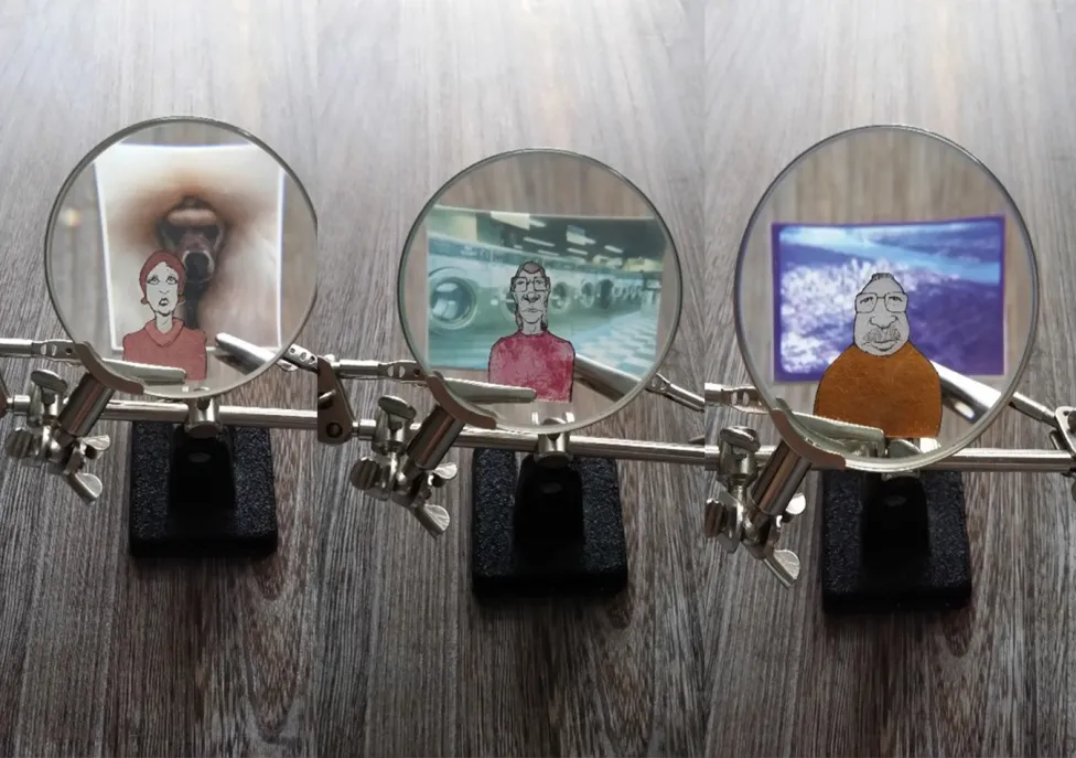 Three small magnifying glasses showing detailed views of three very small portraits