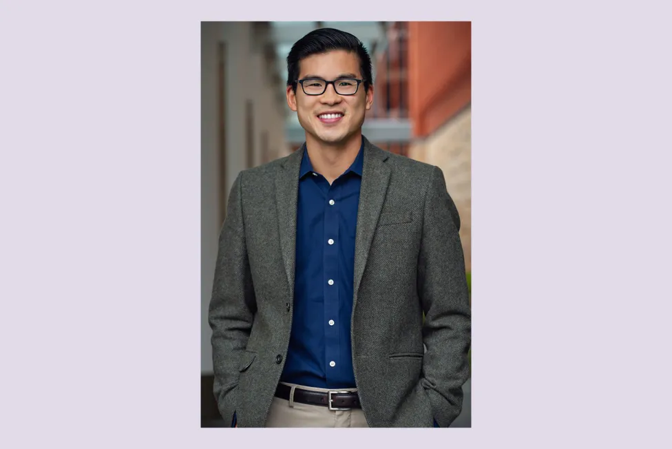 Ian Shin pictured in a gray blazer and dark blue button down shirt with glasses.