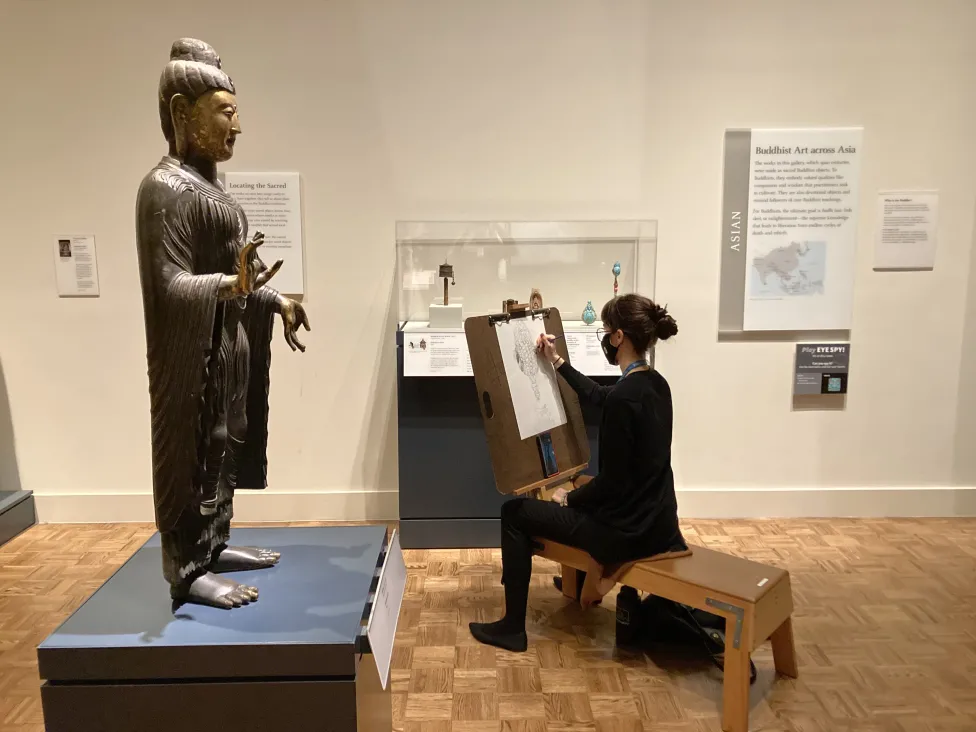 A visitor drawing in the Buddhist art galleries
