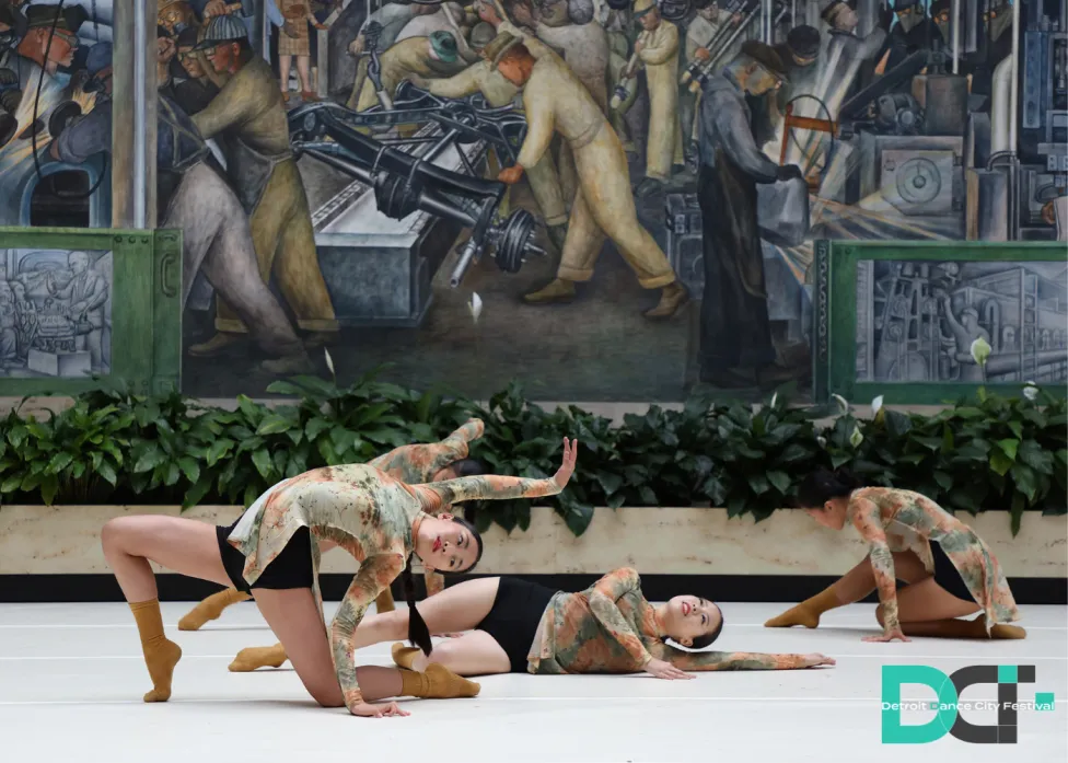 Dancers in various poses on the ground in the DIA's Rivera Court