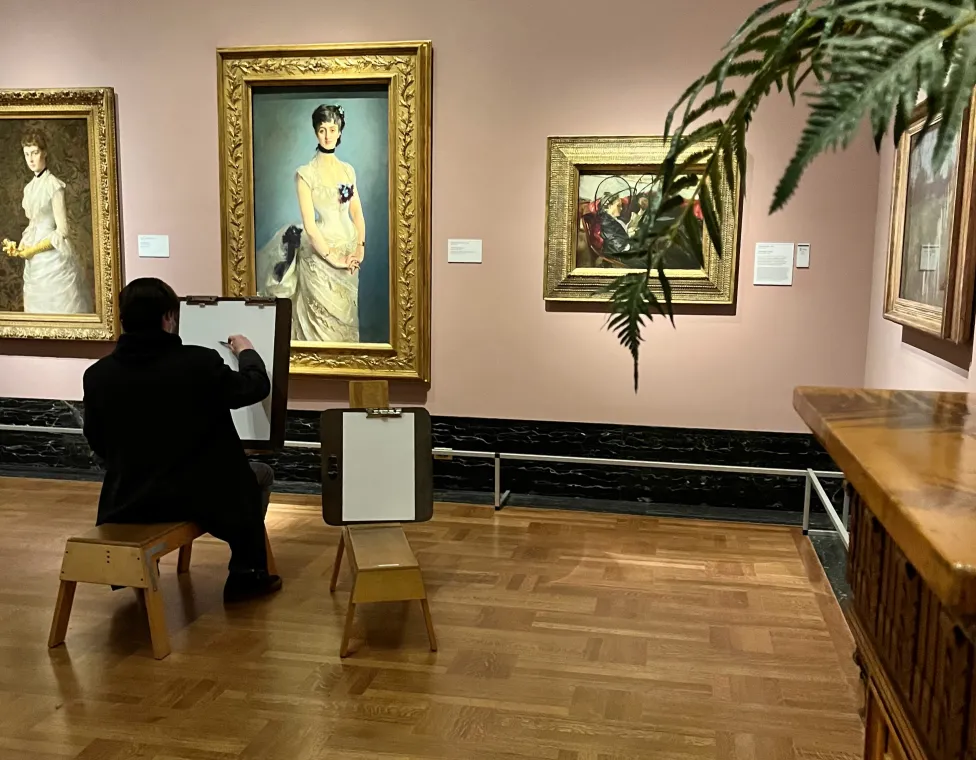 A patron drawing after a portrait of a woman in the American galleries.