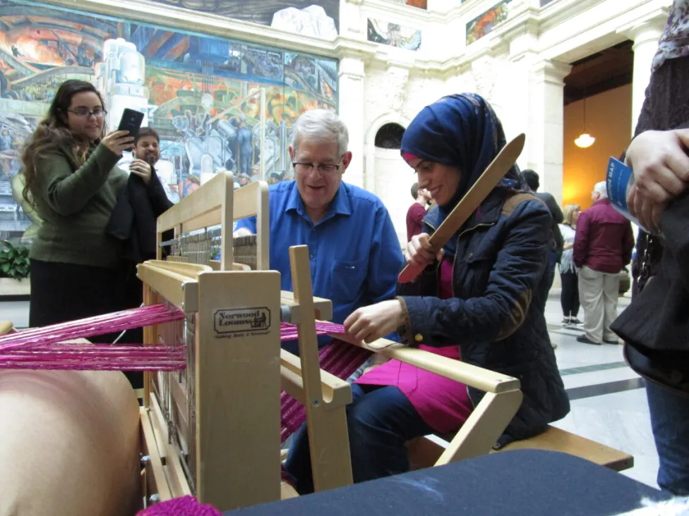 Michael Daitch teaching weaving in Rivera Court on a loom