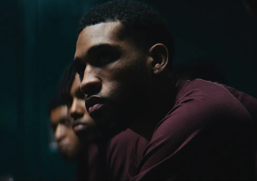 Men in maroon shirts sitting in a row