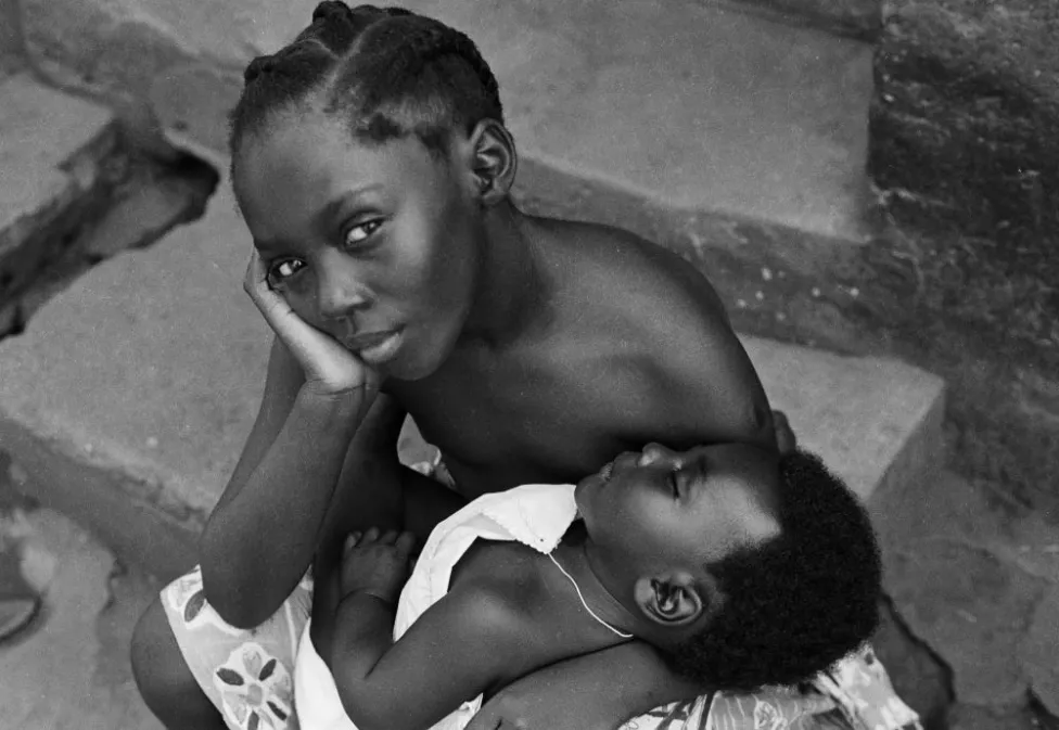James Barnor (Ghana, b. 1929). Sister holding brother outside Studio X23, Accra, 1979 (printed 2010–20). Gelatin silver print. Galerie Clémentine de la Féronnière, Paris. © James Barnor, courtesy Galerie Clémentine de la Féronnière, Paris.