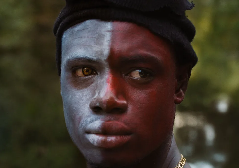 A man with half of his face painted red and half painted white
