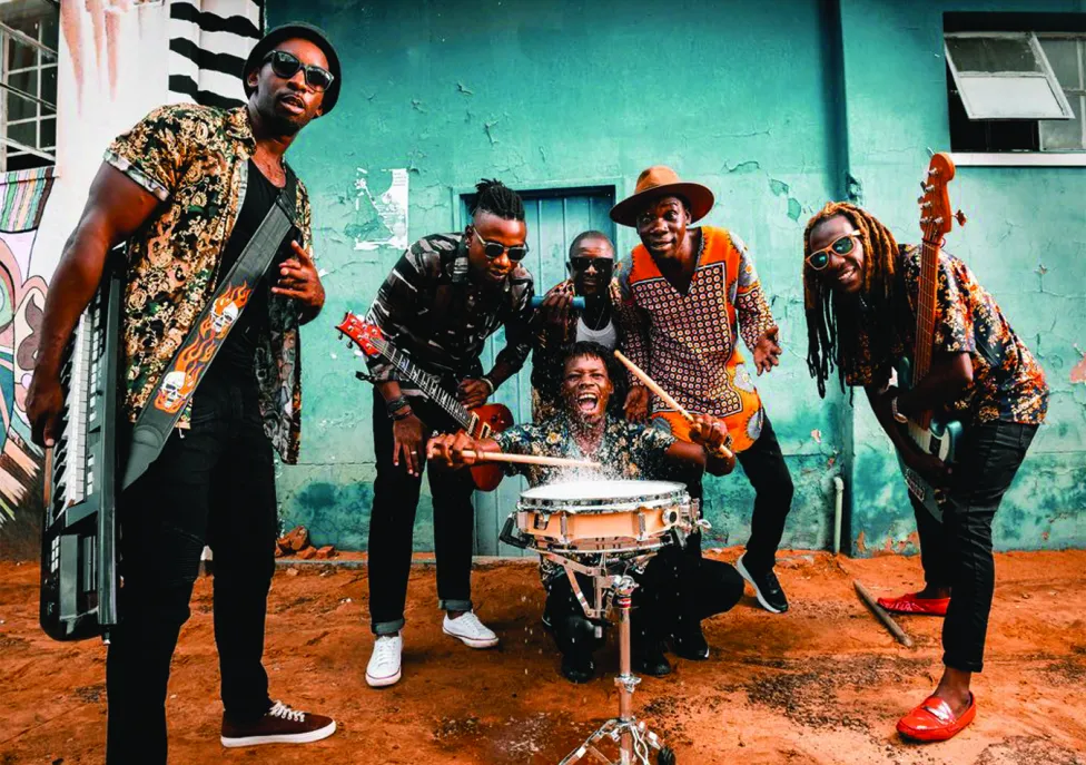 A group of musicians pose together with their instruments