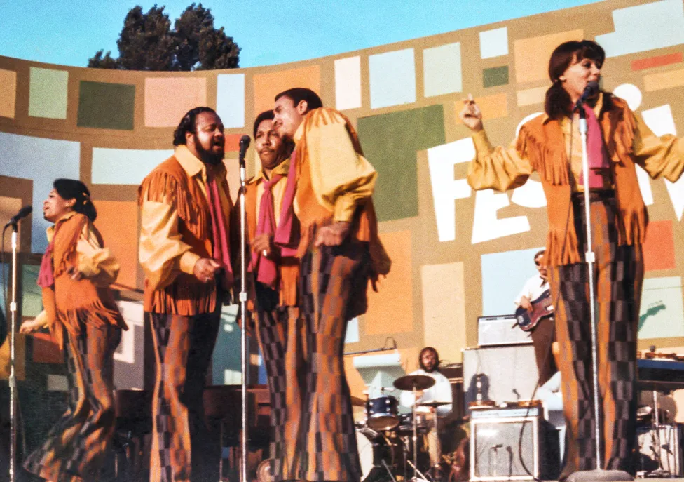 Musicians performing on stage in 70s garb