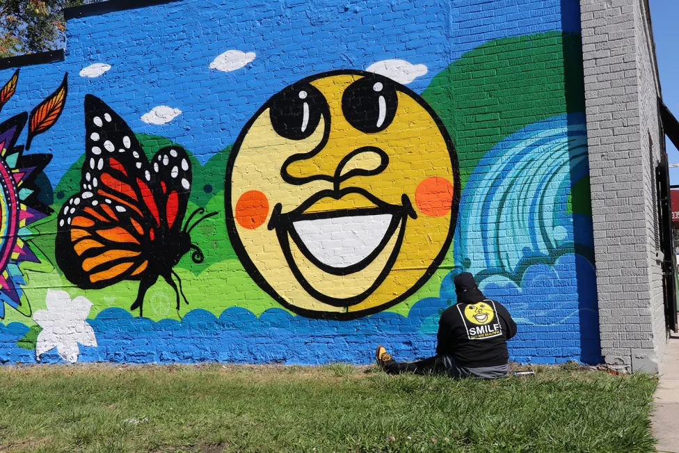 Artist Phil Simpson in front of one of his murals