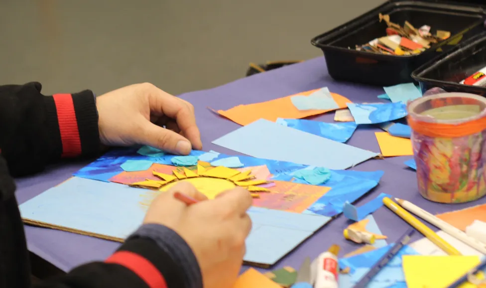Hands work on a paper craft project in the Detroit Institute of Arts' Artmaking Studio