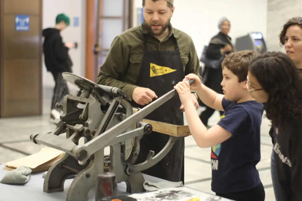 A kid using a printing device in the DIA's Prentis Court