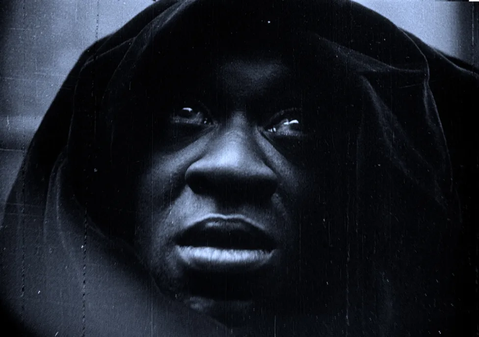 The face of a man covered with a dark hood