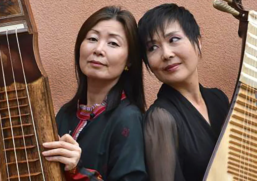 Two women holding large string instruments