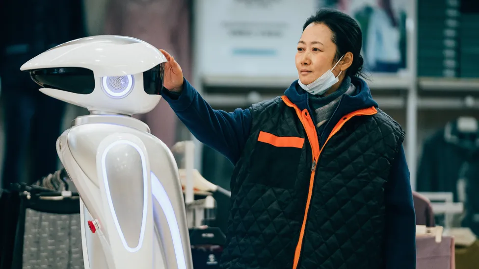 A woman reaching out to a robot