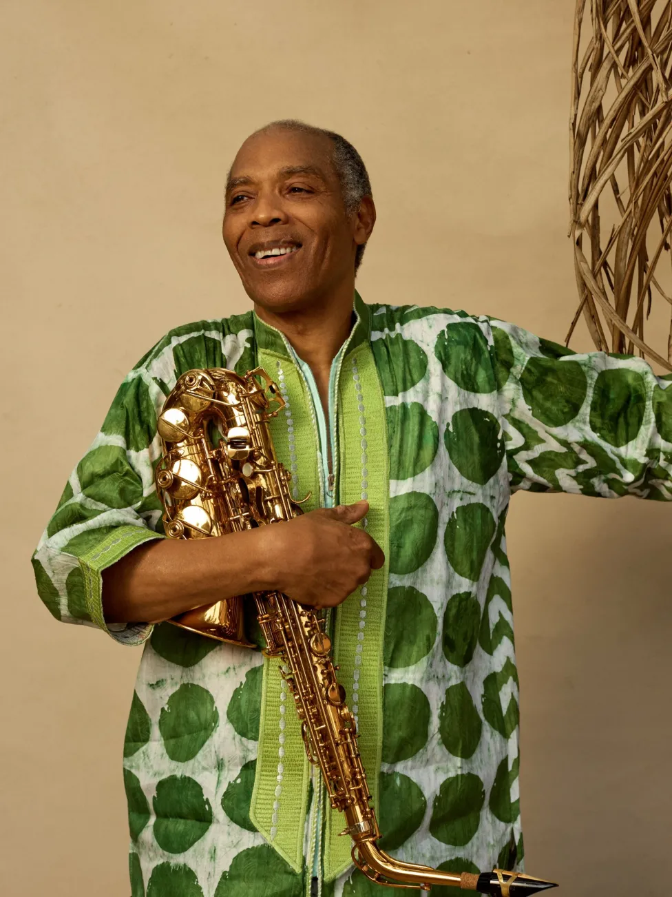 Femi Kuti pictured holding a saxophone upside-down