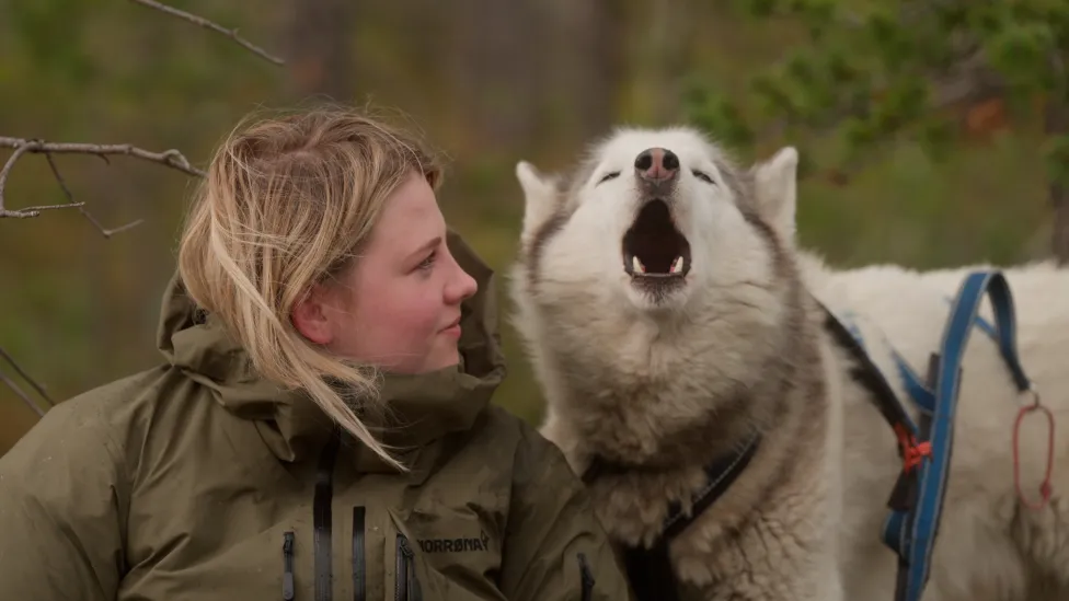 A blond woman with an Alaskan husky