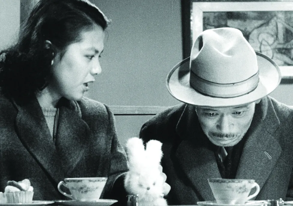 A man and a woman drinking out of tea cups