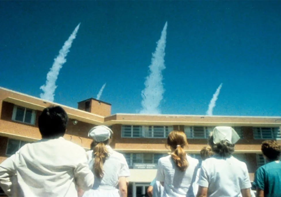 People stop to look at smoke in the sky
