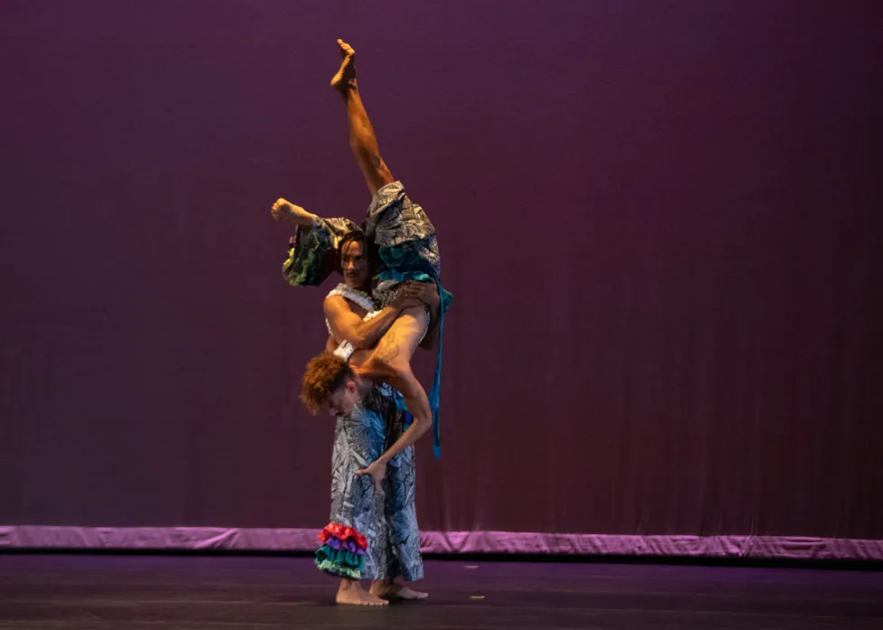 One dancer holding another upside down onstage