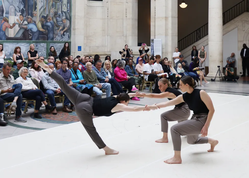 Dancers performing in Rivera Court, with spectators lined against the walls