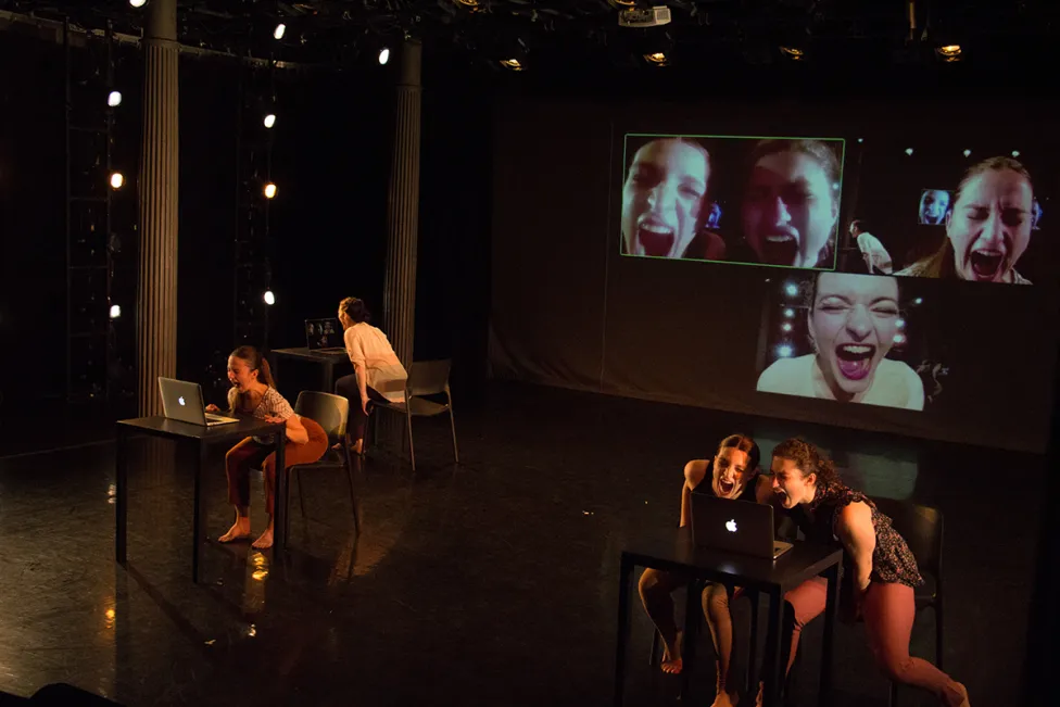 Dancers on stage with their faces on screen