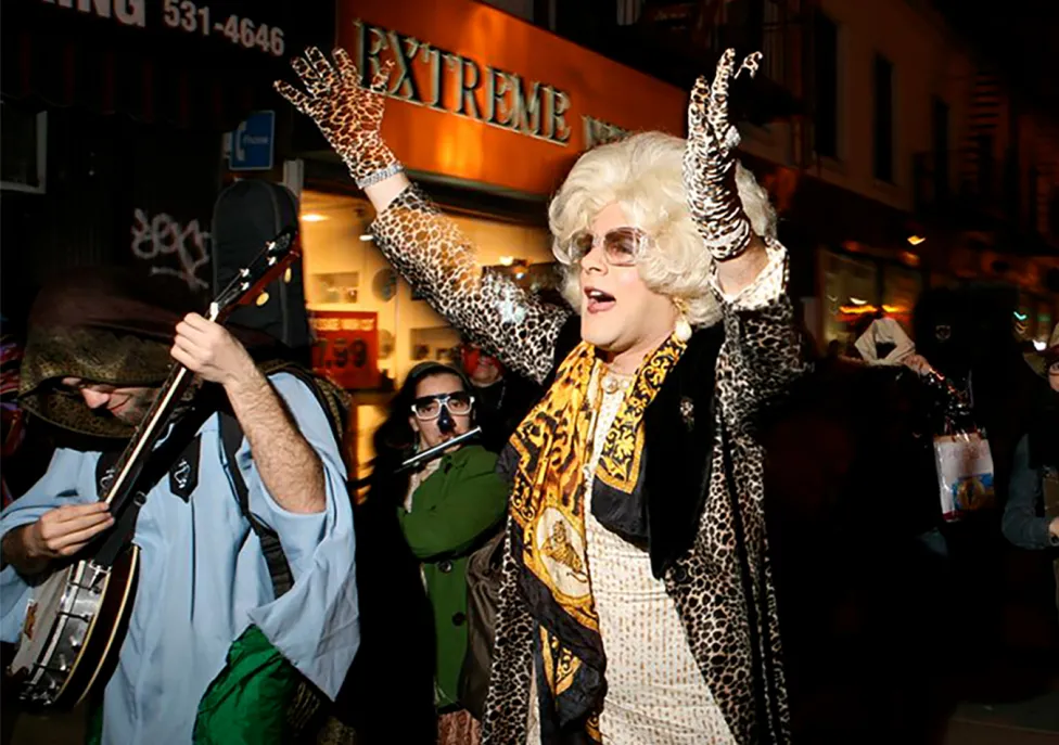 A still from Sabbath Queen with a drag queen in a big, blonde wig