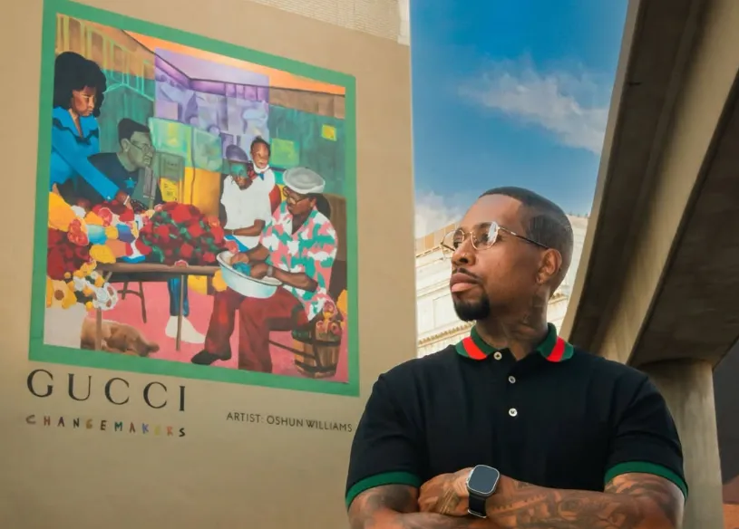 Oshun Williams posing next to one of his works