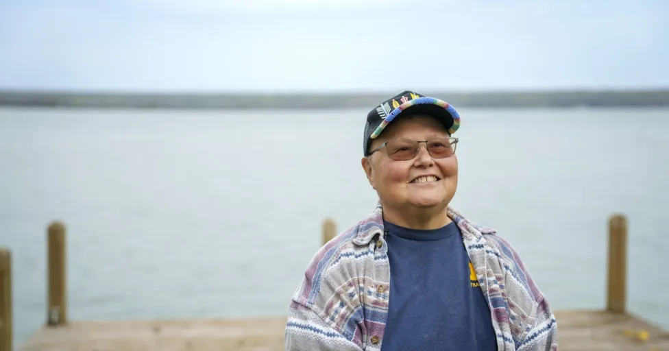 A person standing in front of a dock at a lake