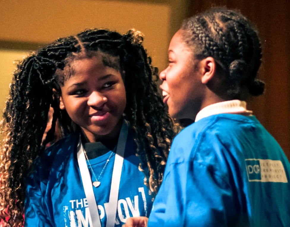 Students on stage at an improv project performance