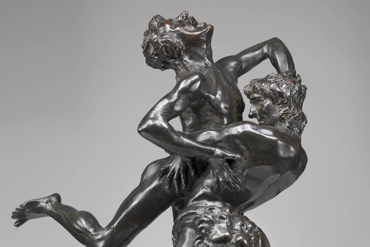 A sculpture featuring two men engaged in a vertical wrestling match by Antonio Del Pollaiolo.