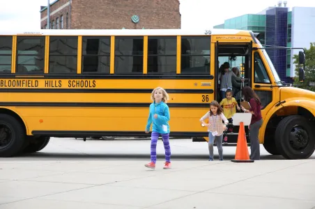 Students getting off a school bus to go on a field trip. 
