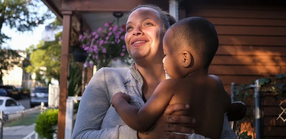 Ashley holds her son Nathaniel on the front porch