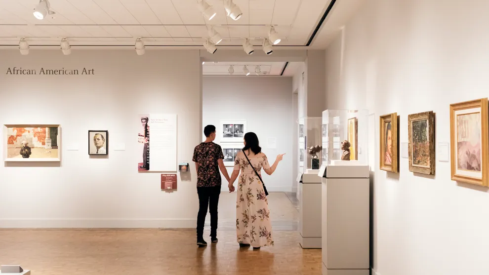 A couple strolling hand-in-hand in the DIA's African American Art galleries