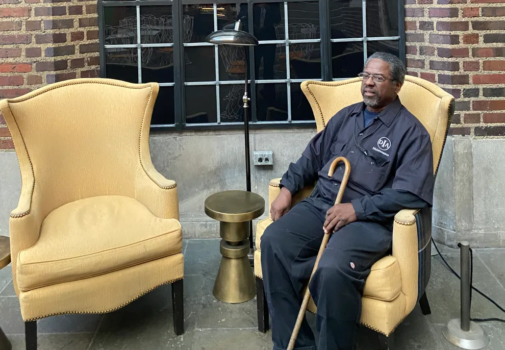 James Burts sits on a winged-back chair in Kresge Court.