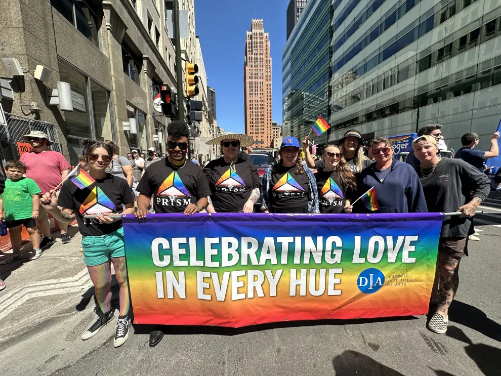 DIA staff and Prism members pose with their Pride parade banner
